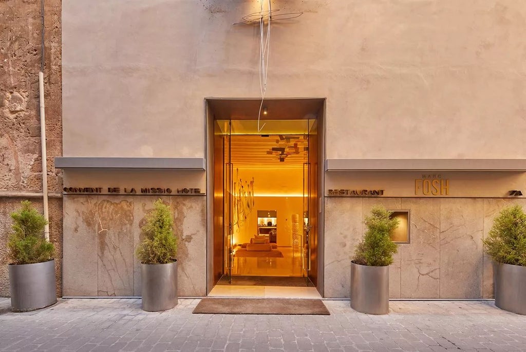 Elegant stone facade of historic Convent de la Missió hotel in Palma, showcasing refined Mediterranean architecture with warm limestone walls and arched windows