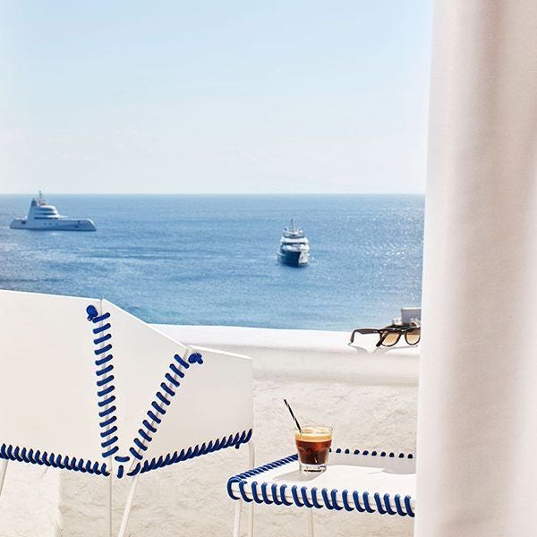 Luxurious white minimalist hotel room with panoramic Aegean Sea view, sleek modern design, and crisp linens at Myconian Ambassador Hotel in Mykonos, Greece