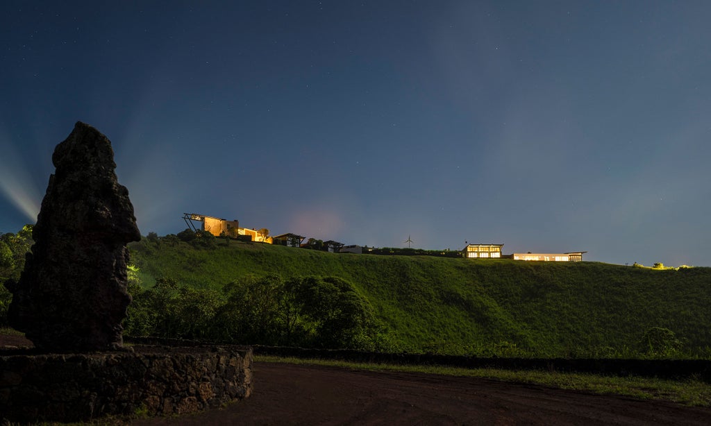 Luxury eco-lodge perched on volcanic terrain, offering panoramic views of Galapagos landscape with modern architecture blending seamlessly with pristine nature.