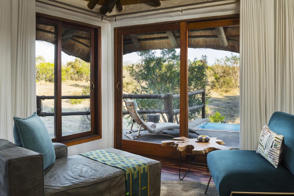 Luxurious stone and wood lodge perched atop rocky cliffs in South Africa, offering panoramic savanna views with infinity pool