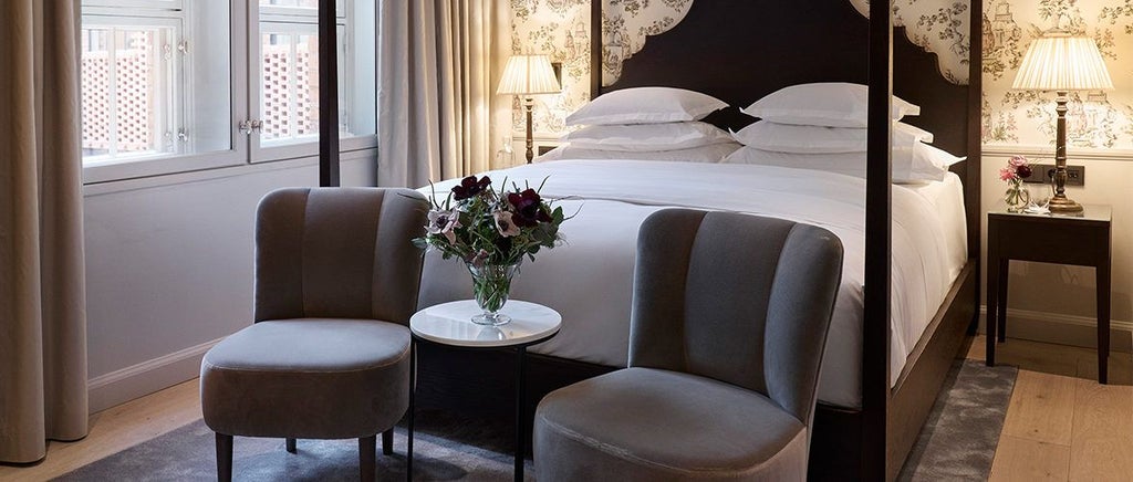 Elegant Scandinavian-style deluxe hotel room with soft neutral tones, plush bedding, minimalist decor, and warm wood accents in Swedish design aesthetic