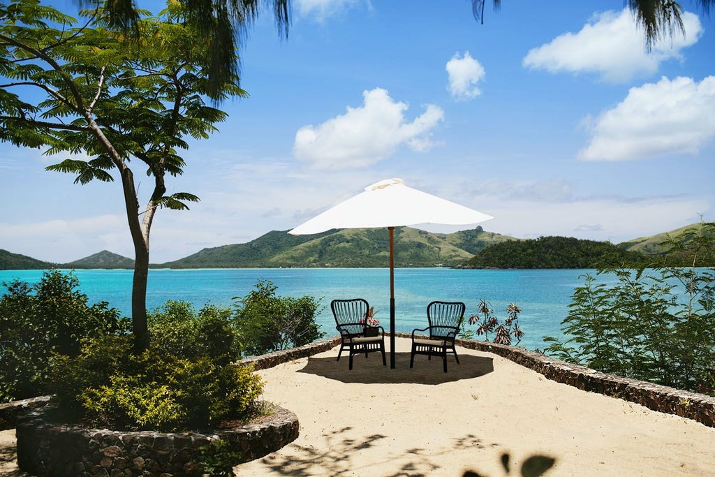 Luxurious beachfront villa at Turtle Island, Fiji, with elegant wooden interiors, panoramic ocean views, and plush king-sized bed overlooking turquoise waters