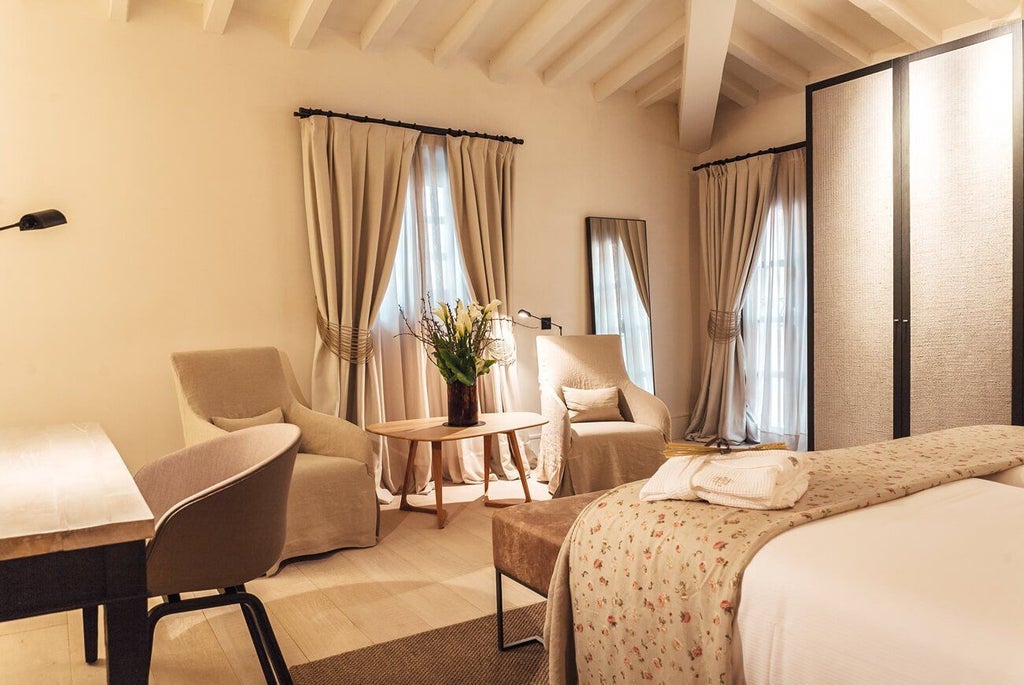 Elegant junior suite at Sant Francesc Hotel Singular, featuring modern design, plush white bedding, and soft natural light in a sophisticated Spanish hotel room