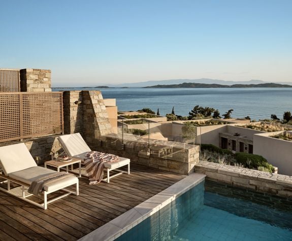 Spacious luxury villa with private infinity pool overlooking Aegean Sea, contemporary Greek design, wooden deck, and panoramic ocean horizon