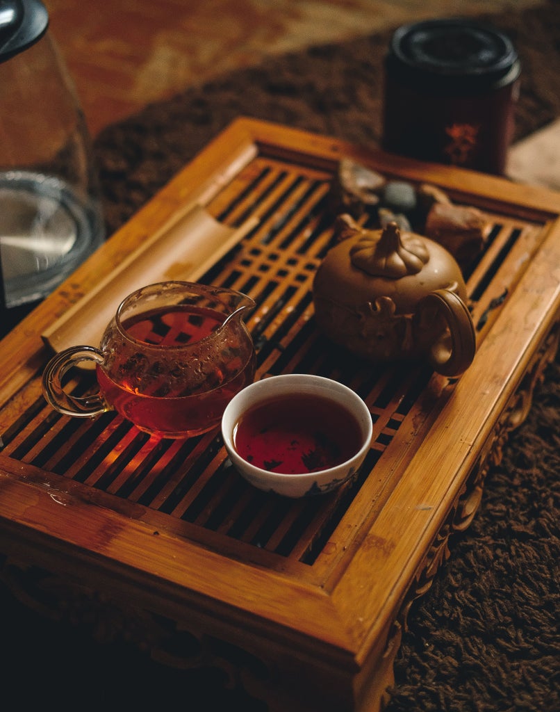 Traditional Korean tea ceremony setup with elegant ceramic teapot, delicate cups, and lavish multi-course meal presentation on pristine white tablecloth in refined dining setting