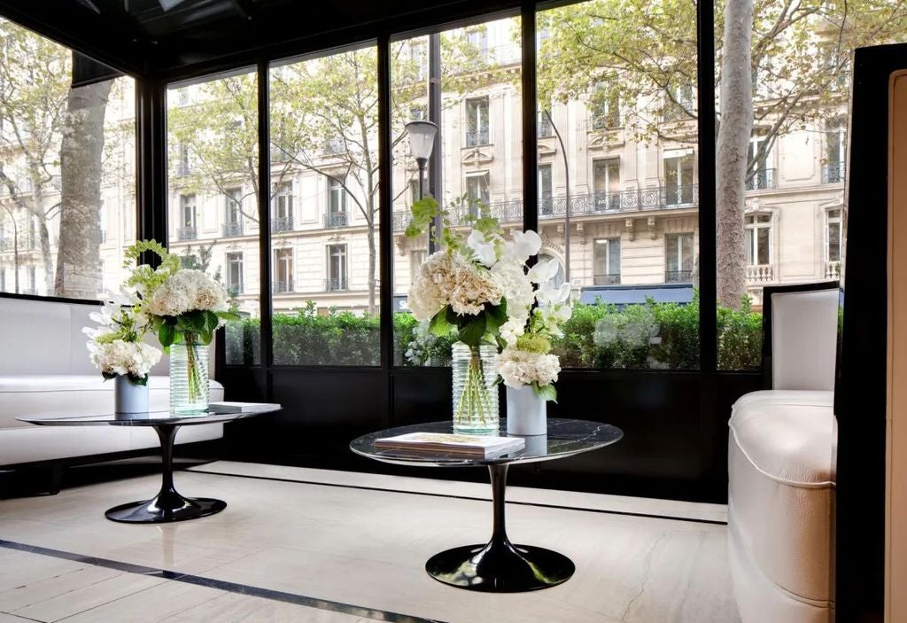 Elegant Art Nouveau facade of Hotel Bowmann in Paris features ornate stone carvings, wrought-iron balconies and classic French windows