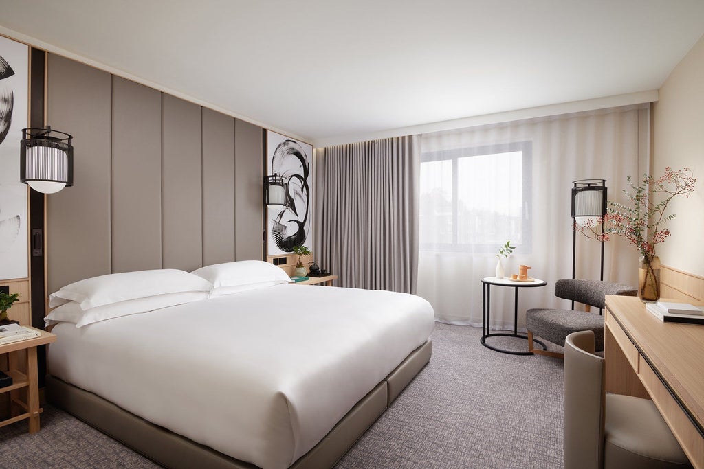 Elegant Deluxe Room at Nobu Hotel London Portman Square, featuring minimalist design, king bed, contemporary artwork, and city-view windows