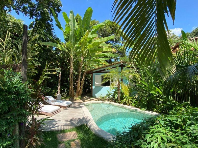 Rustic-chic wooden bungalow with tropical decor, white linens, and bohemian charm at UXUA Casa Hotel in Trancoso, Brazil's coastal paradise