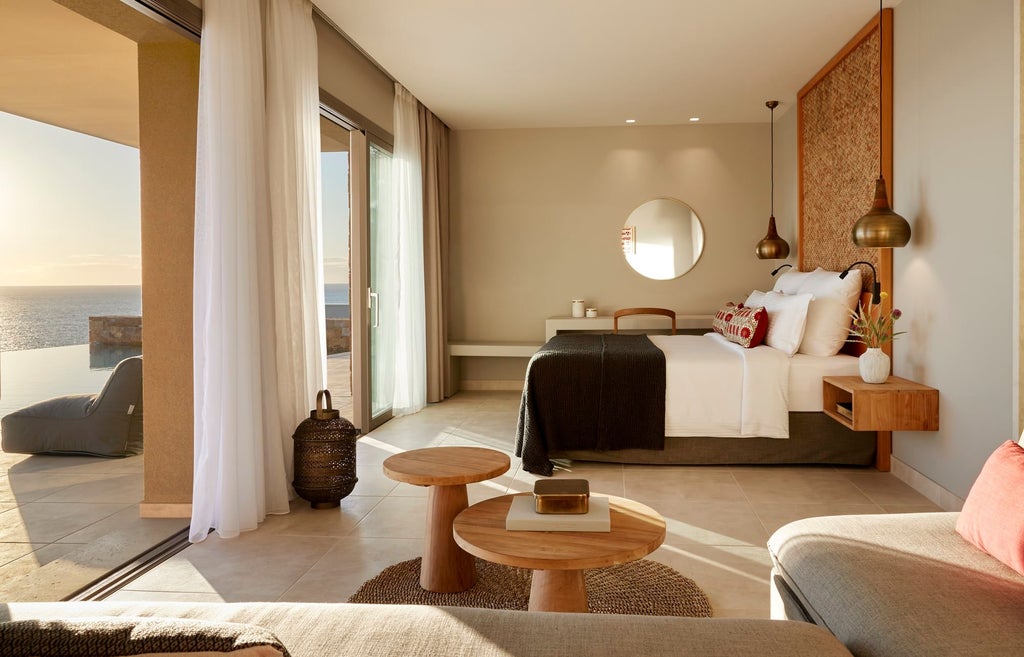 Elegant modern hotel room with panoramic Aegean Sea view, featuring minimalist design, crisp white linens, and sleek contemporary furnishings in Greece