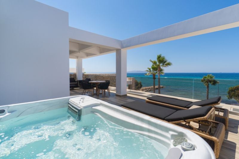 Luxurious master suite with panoramic Aegean Sea view, featuring a spacious private jacuzzi and elegant contemporary design at scenset Design Hotel & Spa.