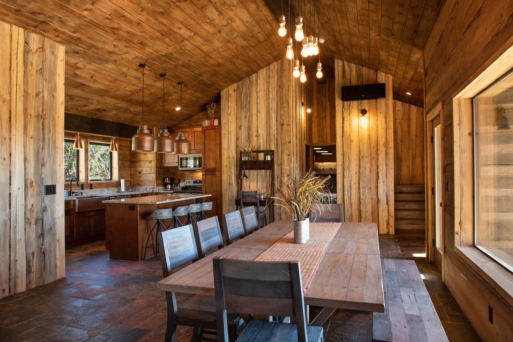 Rustic luxe lodge room with wooden furnishings, plush bedding, and panoramic mountain views of wilderness landscape near scenic national park