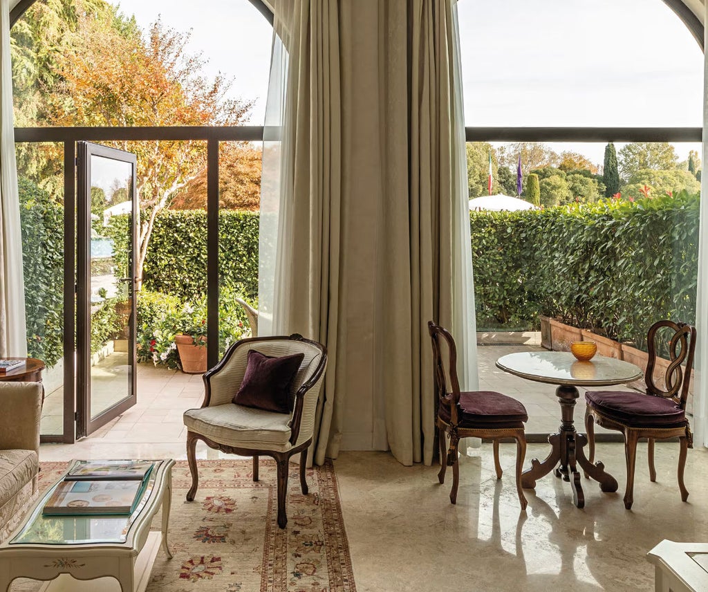 Elegant junior suite with private terrace overlooking pool, featuring marble bathroom, king bed, and classic Venetian decor details