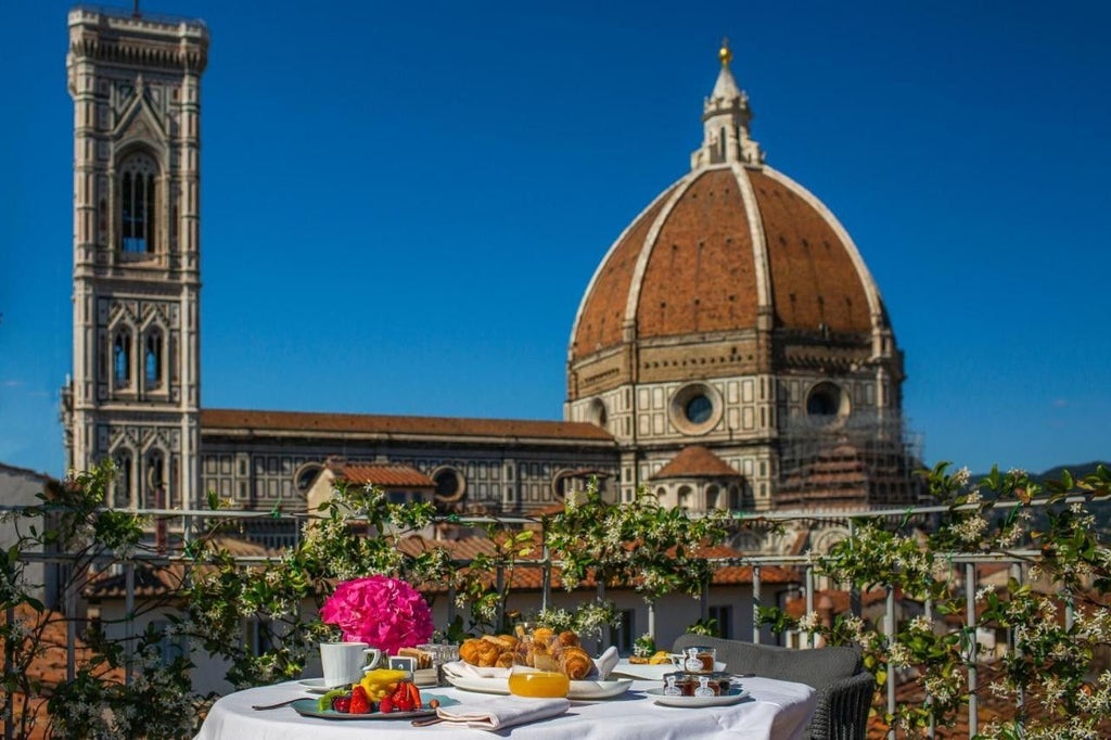 Gothic architecture of Hotel Brunelleschi with elegant arched windows and stone facade, nestled in a charming Italian piazza at sunset