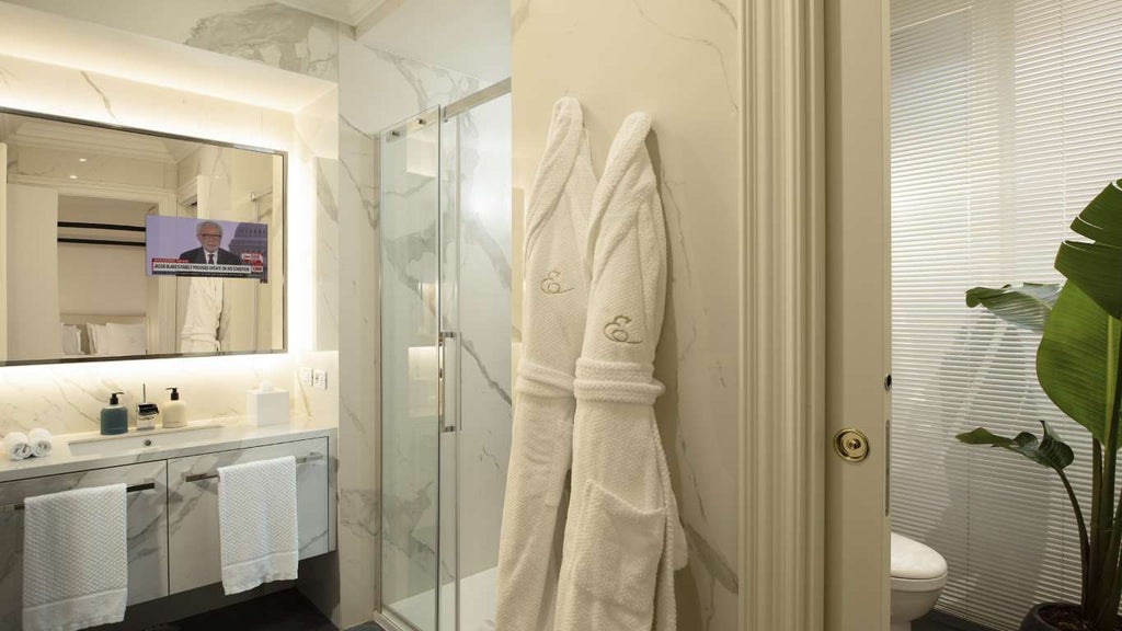 Luxurious deluxe spa hotel room with elegant contemporary design, soft neutral tones, modern furnishings, and sophisticated Italian architectural details in Rome