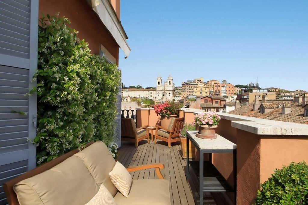 Luxurious Portrait Roma penthouse suite with elegant Italian design, panoramic city views, spacious family accommodation, and sophisticated modern decor