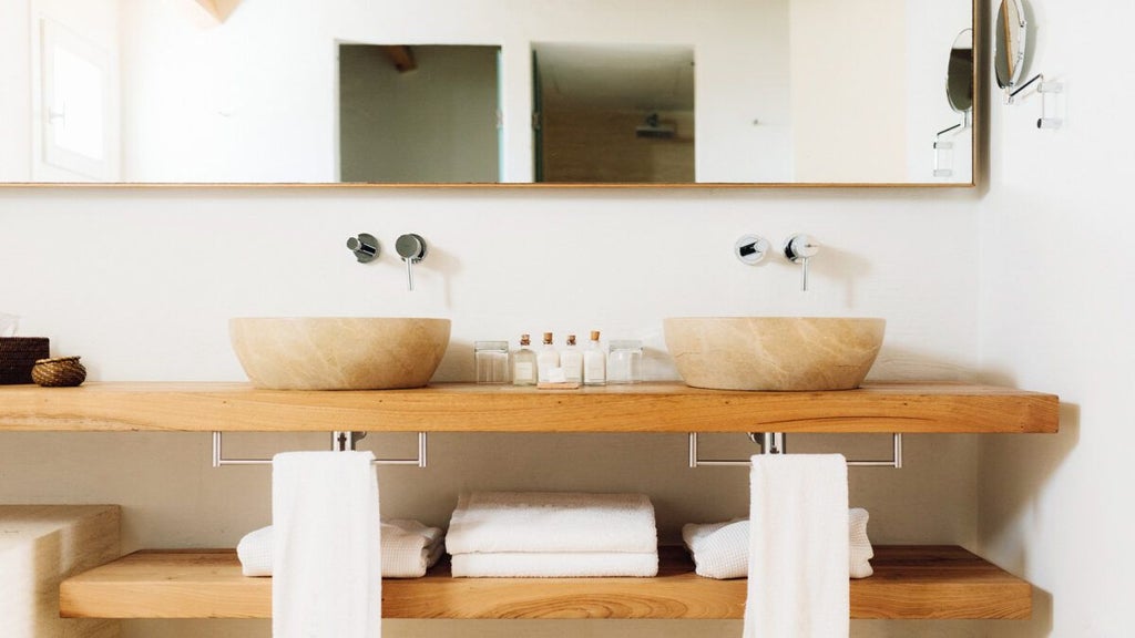 Elegant Mediterranean hotel room with white minimalist design, large windows overlooking azure coastline, rustic stone walls and modern luxe furnishings