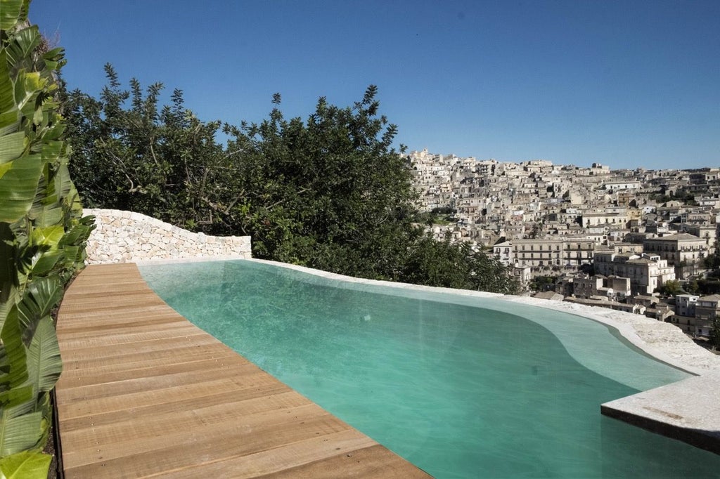 Rustic stone terrace overlooking rolling Sicilian hills, with elegant outdoor seating and warm Mediterranean sunlight at Hotel Scenset Talía