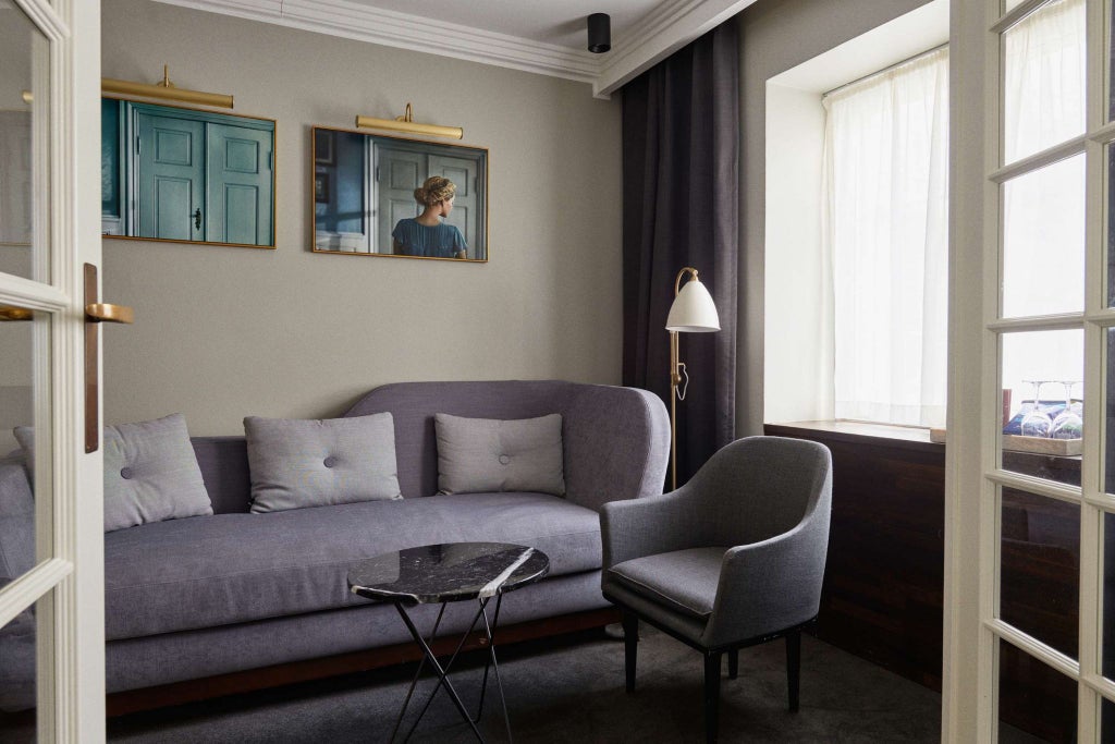 Spacious Danish junior suite with elegant modern decor, plush king bed, large windows, soft neutral color palette, and minimalist Scandinavian design aesthetic