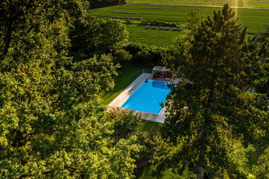 Historic Italian villa with elegant stone facade, manicured gardens, and classic terracotta roof surrounded by towering cypress trees