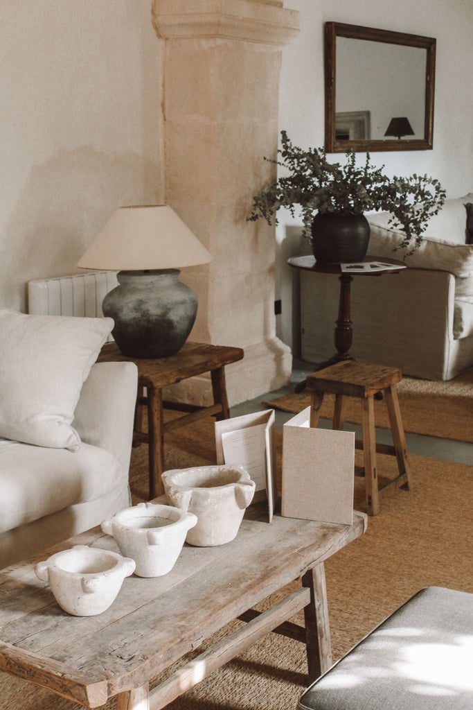 Small whitewashed Spanish village with stone houses nestled on a hilltop, surrounded by vast countryside in golden afternoon light