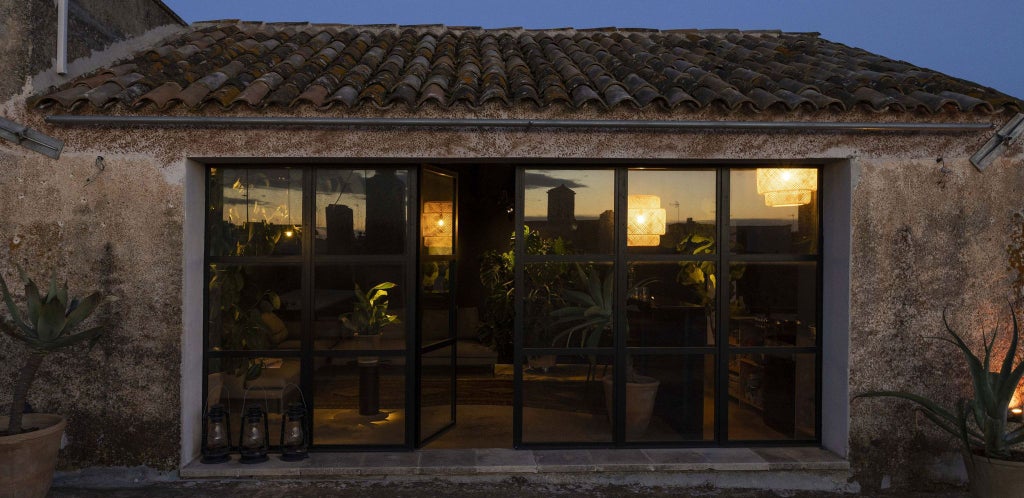 Elegant black-themed luxury suite with minimalist decor, high ceilings, sleek Italian furnishings, and dramatic architectural details in Palazzo Daniele