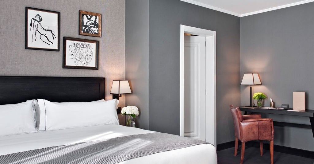 Elegant hotel suite in Madrid, featuring plush king bed, contemporary Spanish design, large windows overlooking Gran Vía, luxurious neutral color palette