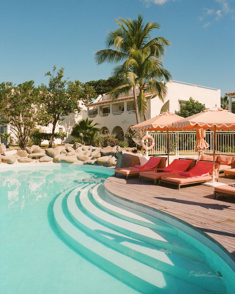 Oceanfront white villa with private infinity pool overlooking turquoise Caribbean waters at La Samanna resort in Saint Martin at sunset