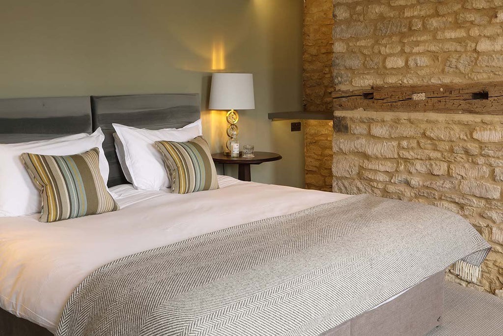 Elegant superior room at Kings Head Hotel, featuring plush bedding, classic wooden furnishings, and soft ambient lighting in a traditional United Kingdom setting