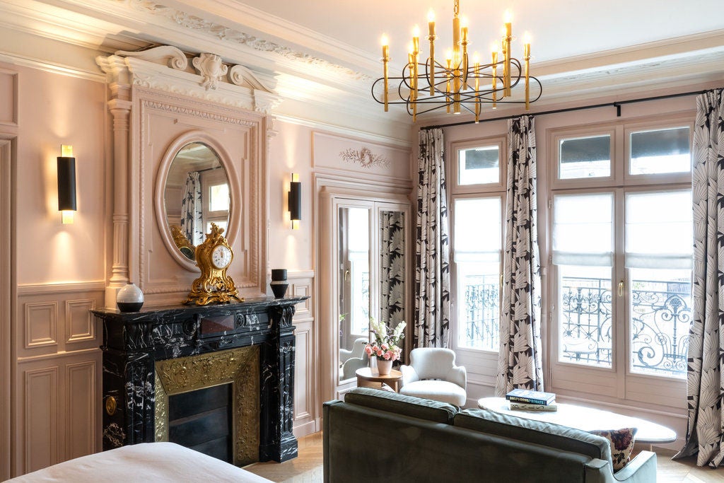 Art Deco-style Parisian hotel with ornate stone facade, wrought-iron balconies, classic French windows, and elegant period lighting fixtures