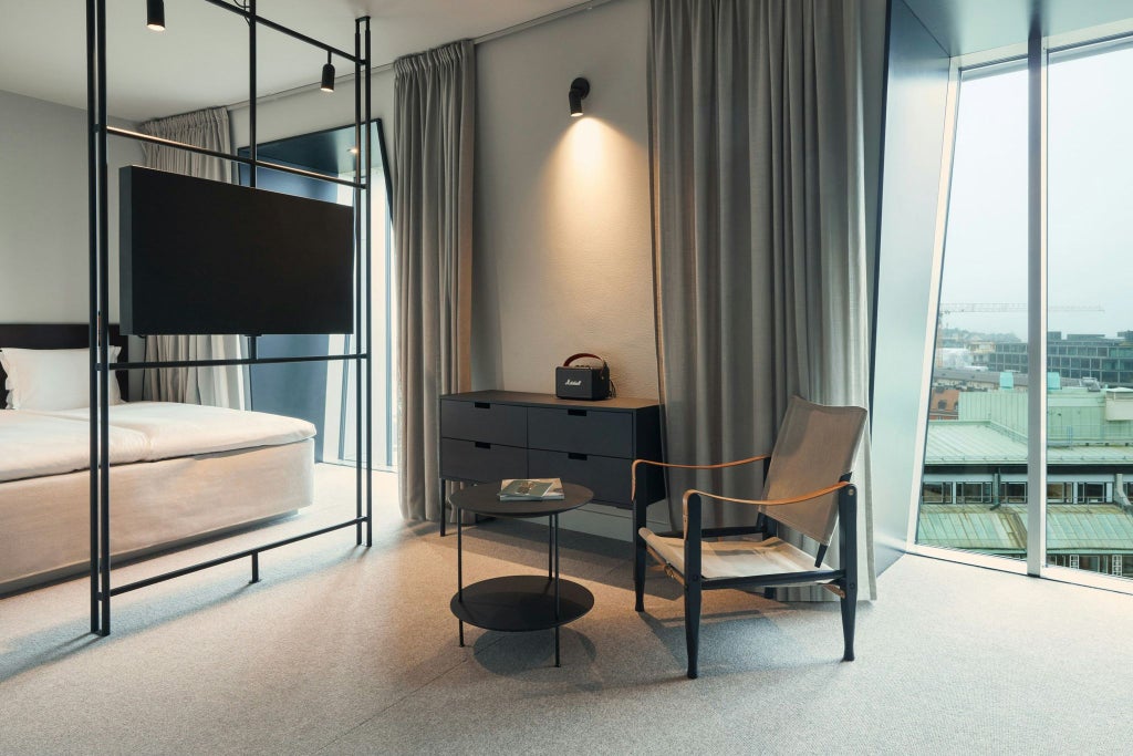 Contemporary Scandinavian studio room with minimalist design, floor-to-ceiling windows, neutral color palette, and sleek modern furniture at Blique by Scenset hotel.