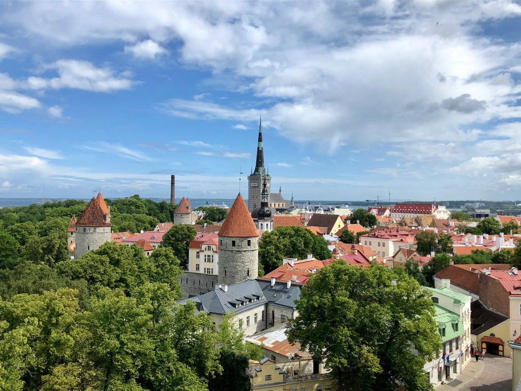 Scenic ferry crossing Baltic Sea, Helsinki skyline fading, Tallinn's medieval towers emerging, travelers enjoying luxurious day trip experience