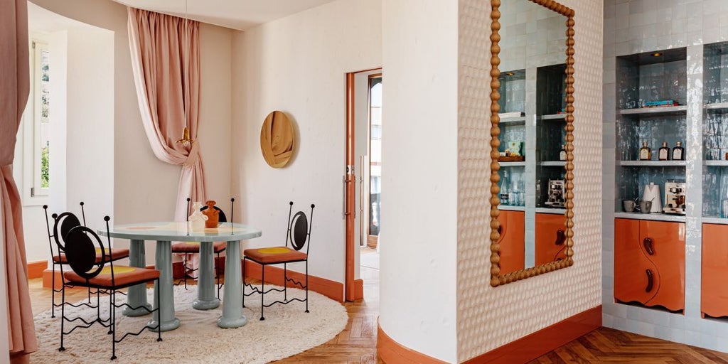 Elegant Dalt Vila Suite with white-washed walls, minimalist design, panoramic Ibiza skyline view, luxurious king bed, and contemporary Mediterranean styling
