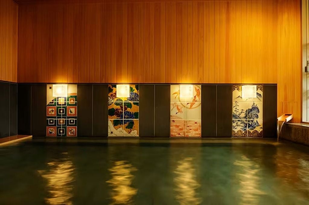 Traditional Japanese luxury ryokan with wooden exterior and glowing lanterns, surrounded by autumn trees next to a tranquil river