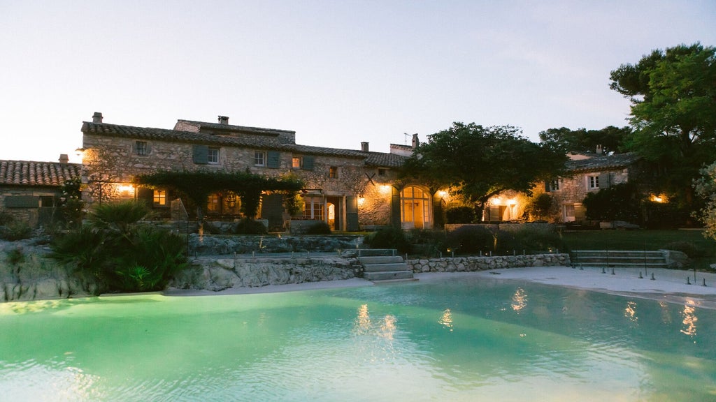 Elegant French countryside hotel with manicured rose gardens, stone facade, and lavender-lined pathway under soft golden sunset light