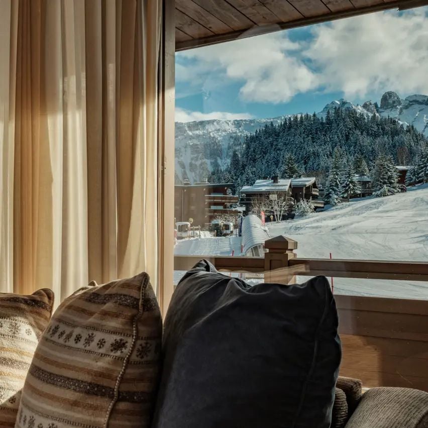 Luxurious alpine chalet-style hotel nestled in snow-capped mountains, featuring elegant wooden facade and modern ski resort ambiance in the French Alps