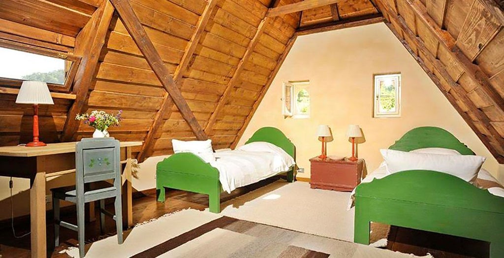 Minimalist white loft-style twin bedroom with elegant wooden flooring, crisp white linens, and large window offering soft natural light in Romanian guesthouse