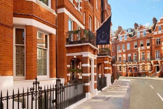 Elegant exterior of luxurious boutique hotel with refined architectural details, ornate facade, and sophisticated London streetscape backdrop