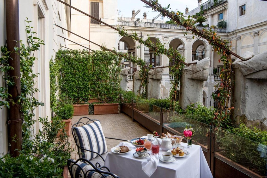 Elegant hotel facade of Hotel Vilòn in Rome, with ornate windows, classic Italian architecture, and lush greenery adorning the entrance