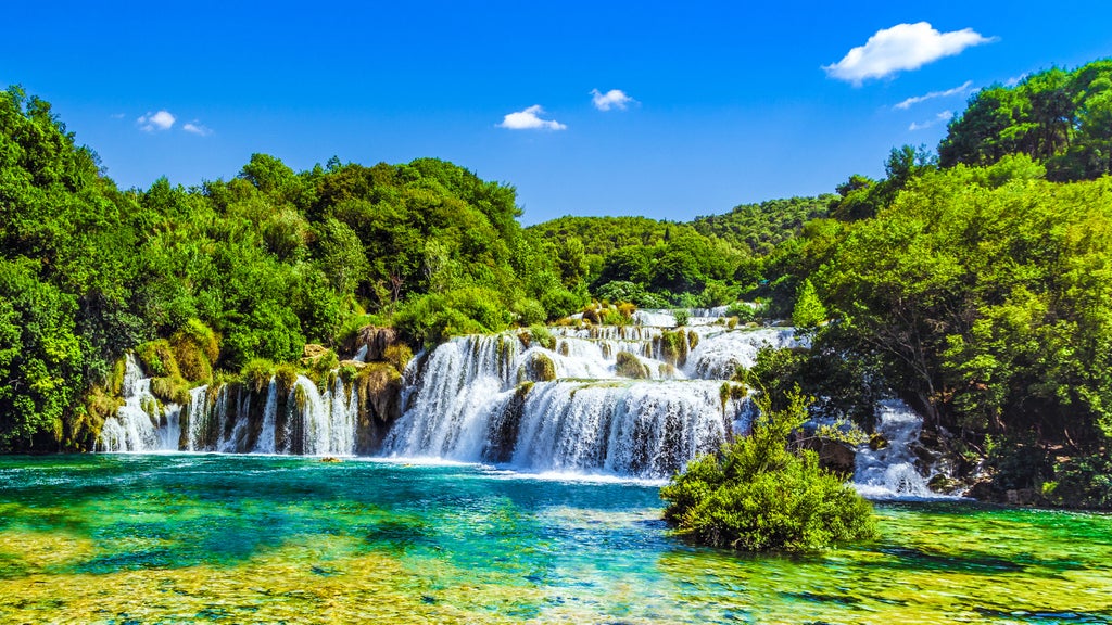 Cascading turquoise waterfalls surrounded by lush forest paths and wooden boardwalks at Croatia's pristine Krka National Park