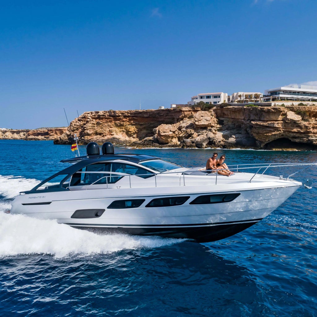 Luxurious white-walled Mediterranean resort overlooking turquoise waters, with minimalist architecture and infinity pool nestled against dramatic Ibiza coastline