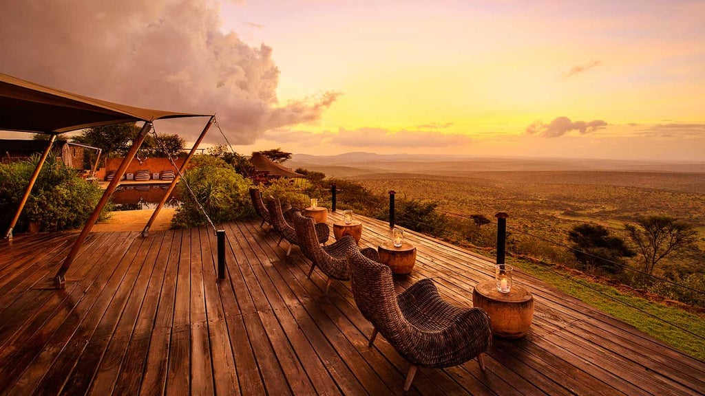 Luxury safari tents overlooking vast savanna landscape with Mount Kenya's silhouette, wooden deck, and elegant outdoor seating at Loisaba Camp