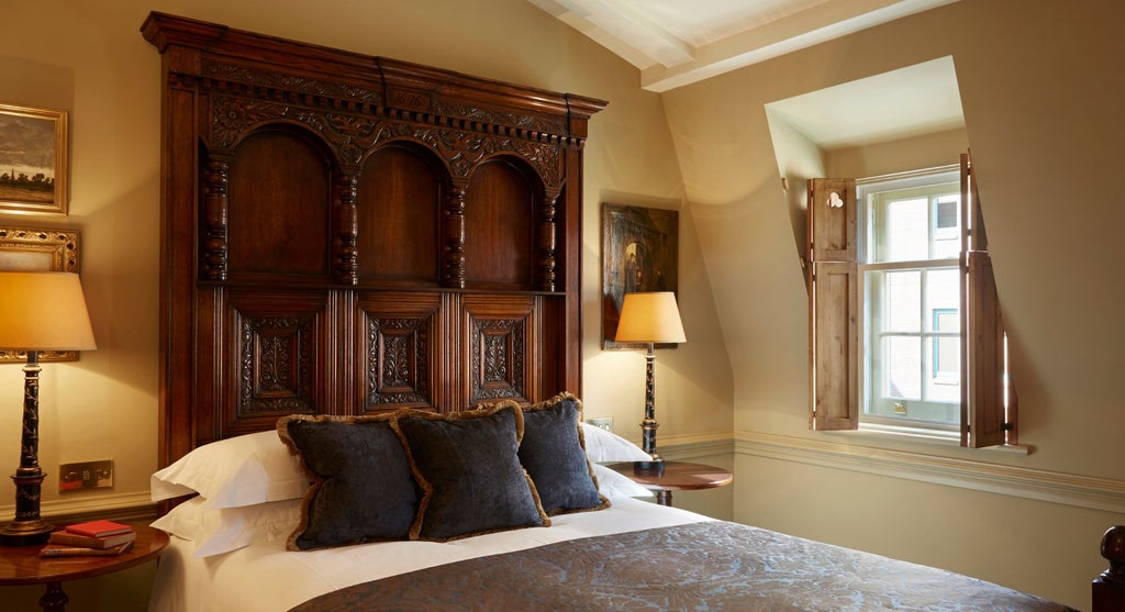 Elegant boutique hotel room with ornate four-poster bed, vintage chandelier, luxurious cream and gold color palette, period-inspired sophisticated decor