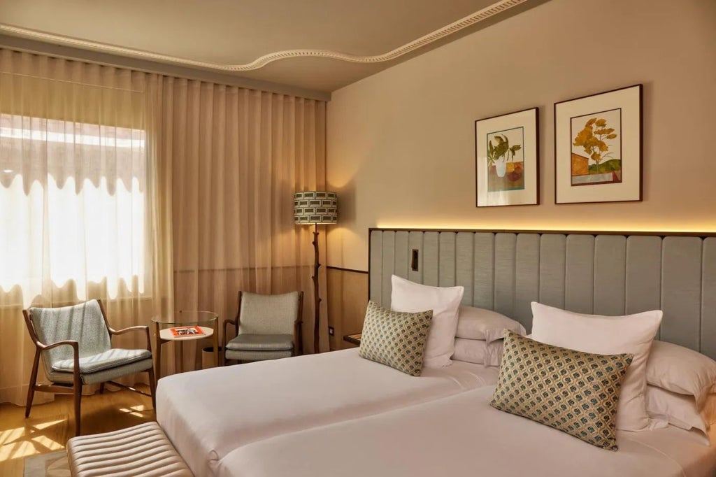 Elegant superior room at Grand Hotel Central with plush white bedding, modern minimalist decor, and expansive city views of Barcelona's skyline