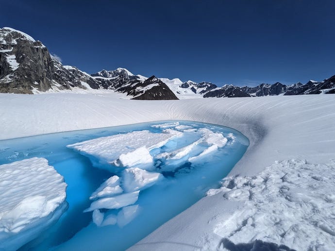 The river descends beneath the nunatak