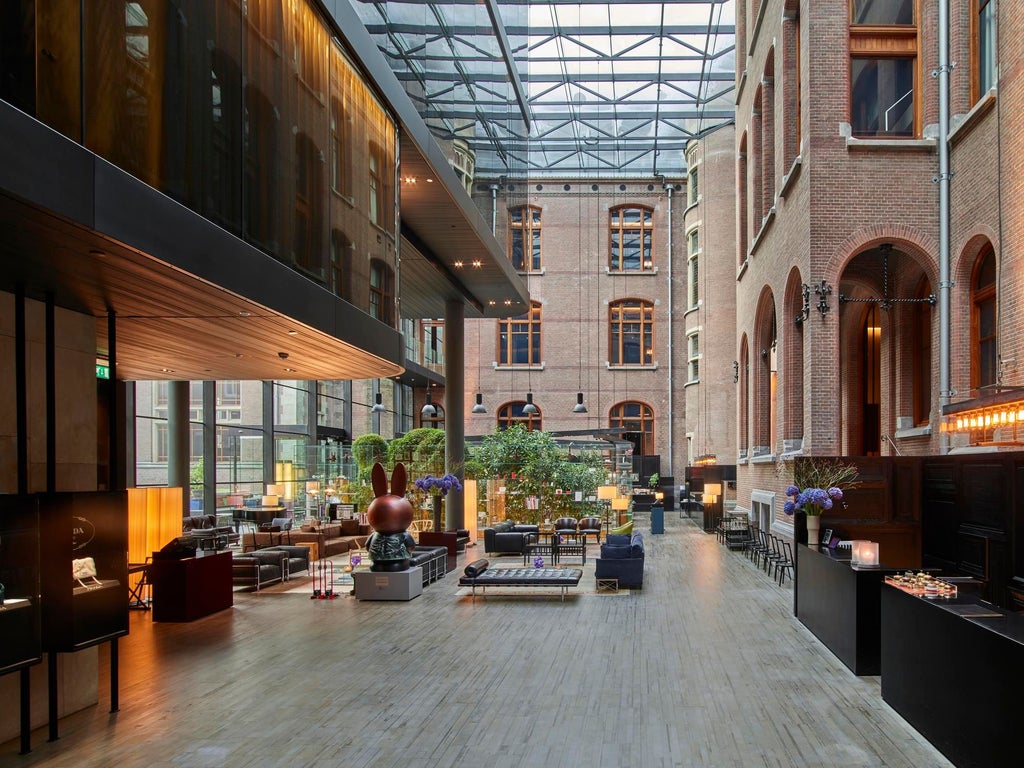 Luxurious glass-fronted Scenset Hotel nestled in historic Amsterdam, blending modern architecture with elegant interior design and warm lighting