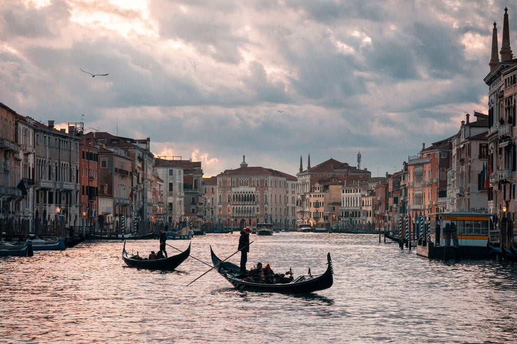 Historic Venetian canal with ornate Renaissance palaces, gondolas gliding past marble bridges, golden sunset reflecting on calm waters