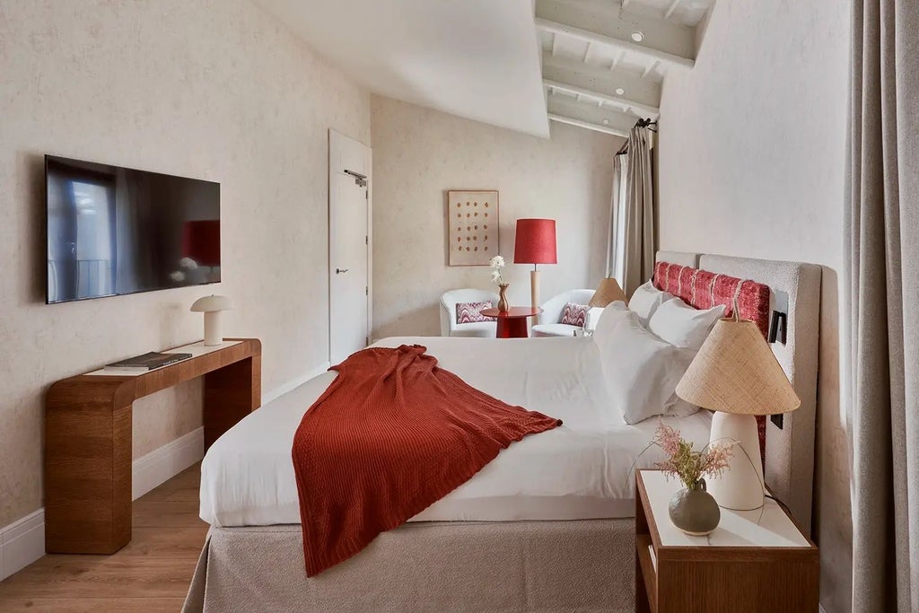 Elegant stone-walled superior room at Posada Terra Santa, featuring plush white bedding, vintage wooden furniture, and warm ambient lighting in Mallorca, Spain