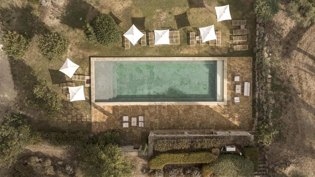 Elegant stone facade of Le Galinier hotel with lavender fields, rustic Provençal style, warm sunlight casting soft shadows on traditional architecture