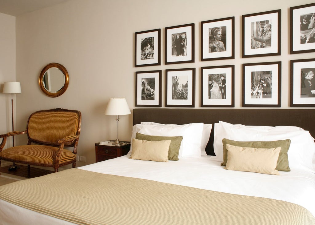 Elegant boutique hotel facade with grand colonial-style windows, ornate ironwork balconies, and warm lighting in upscale Buenos Aires district