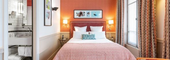 Elegant deluxe hotel room with soft neutral tones, plush bedding, modern minimalist furniture, and large windows overlooking French countryside landscape